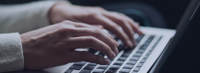 Developer working on code and system updates with a laptop against a high-tech digital background