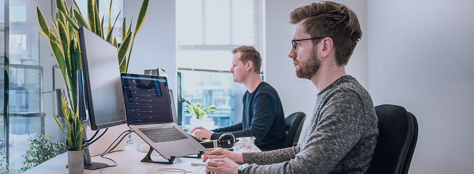 Agile development team coding and collaborating in a contemporary tech workspace with plants