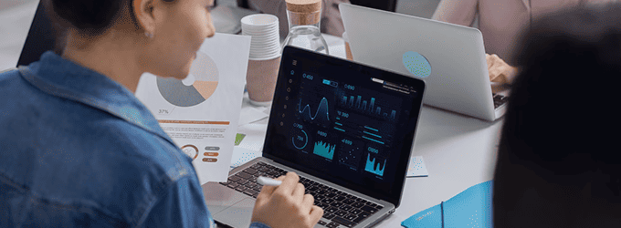 Research analyst interprets key performance indicators presented in colorful dashboard charts.