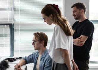 Team collaborating at a workstation, reviewing content on a desktop monitor in a bright modern office.