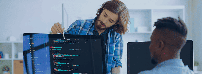Software engineer explaining source code to a team member during a collaborative coding session