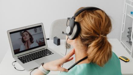 Healthcare professional conducting a virtual patient consultation via laptop using telemedicine technology.
