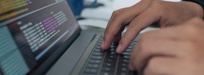 Software engineer conducting quality assurance tests for eCommerce on a laptop
