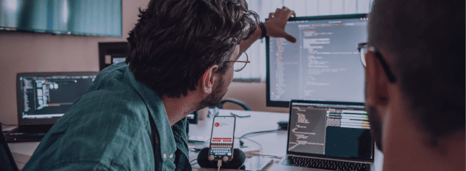 Developers collaborating and reviewing code together in a software project meeting