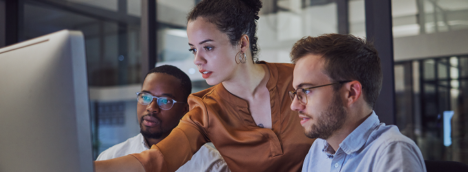 Agile team uniting at a single screen to blend diverse insights to co-create cutting-edge digital solutions