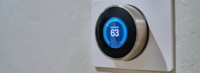 Homeowner monitors indoor temperature via a connected thermostat to optimize climate control.